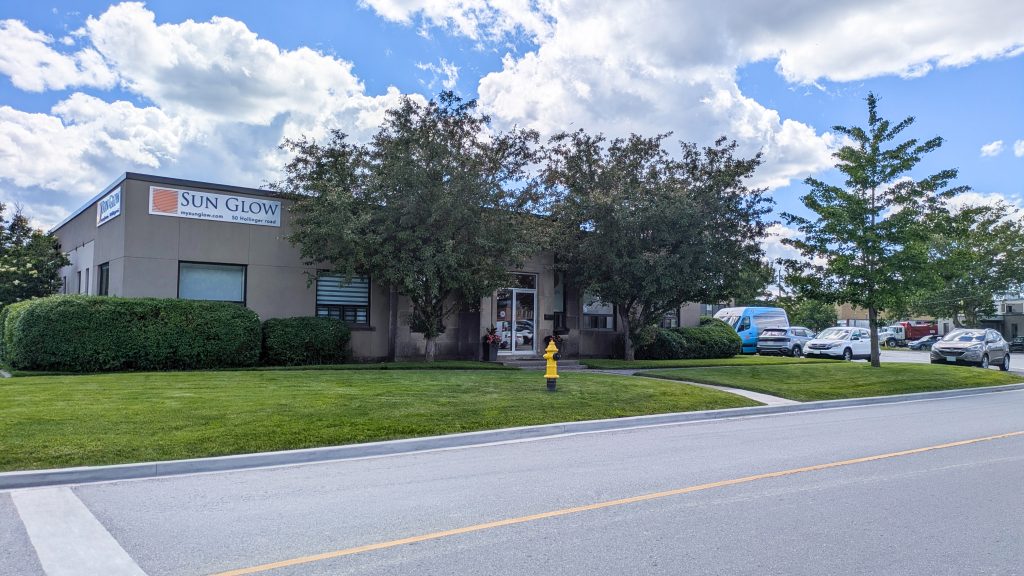 Exterior of the Sun Glow building at 50 Hollinger Road with trees, green lawn, and a yellow fire hydrant