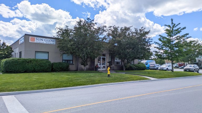 Exterior of the Sun Glow building at 50 Hollinger Road with trees, green lawn, and a yellow fire hydrant