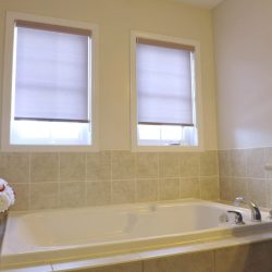 Grey sunscreen roller shades for washroom