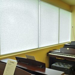 Sunscreen roller shades for music academy